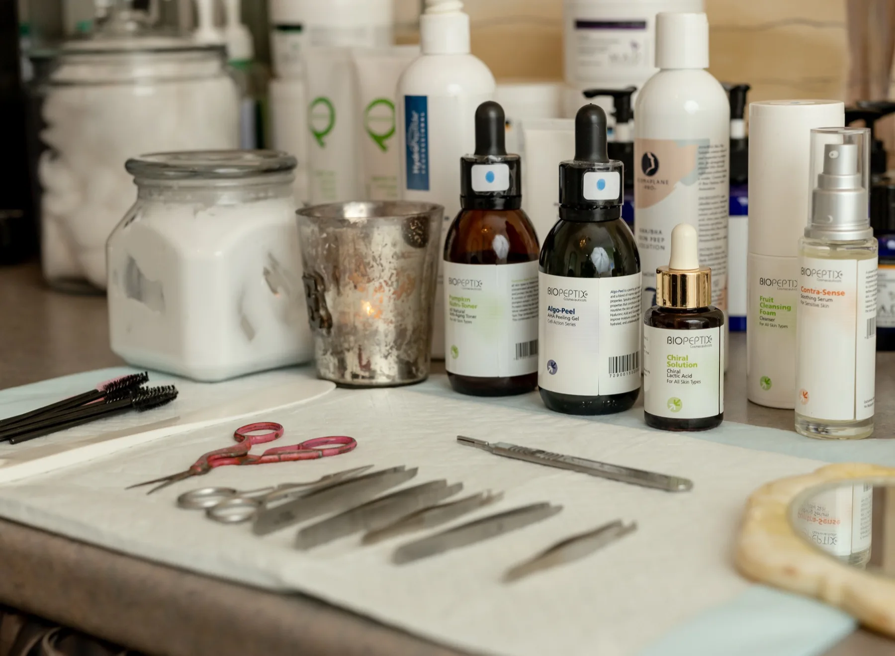 Organic skincare serums and freshly sanitized tools laid out on a clean cloth before a facial at our Aspinwall spa