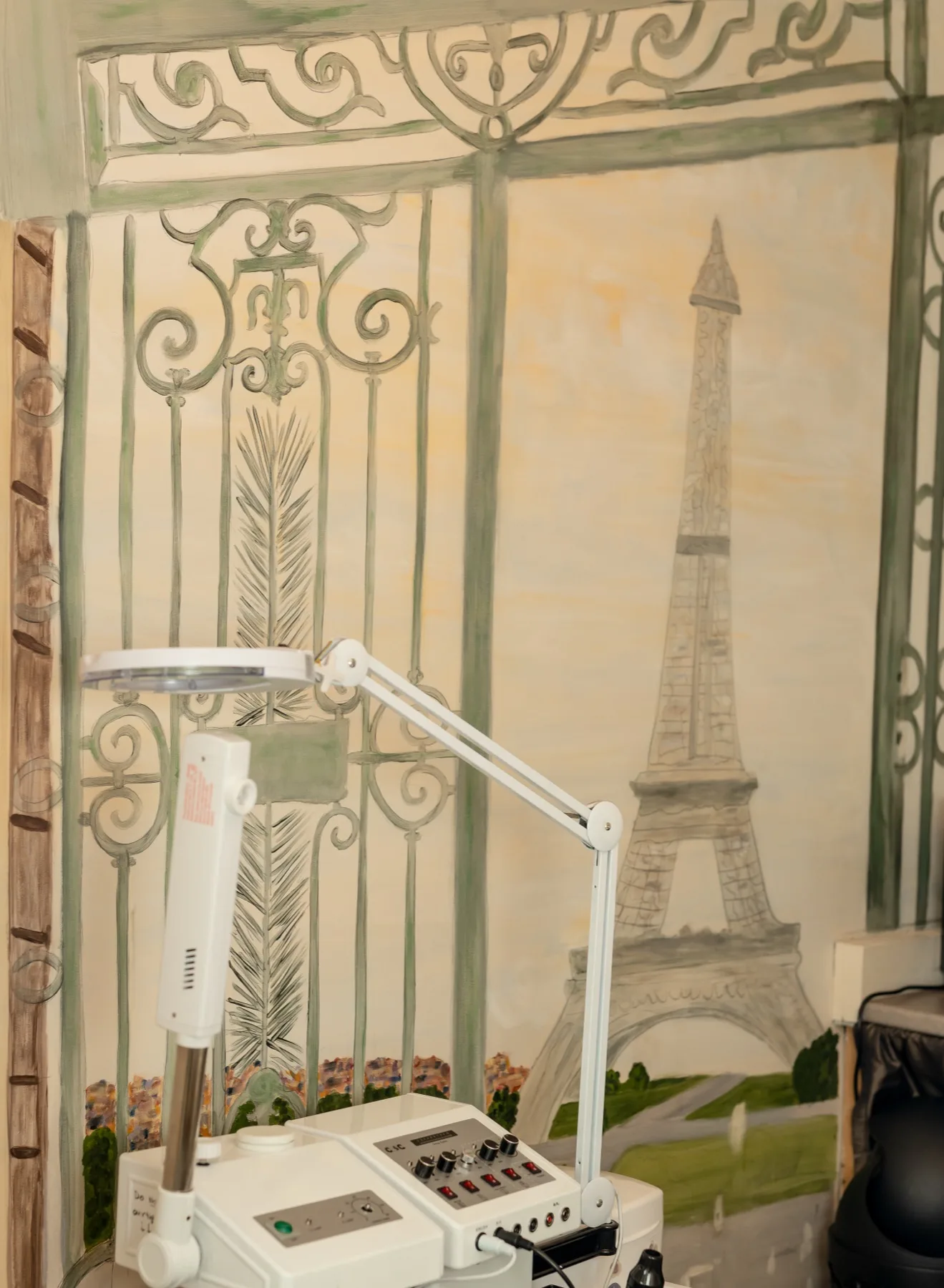 A close-up of the professional treatment lamp and skincare equipment in one of our Paris-mural treatment rooms