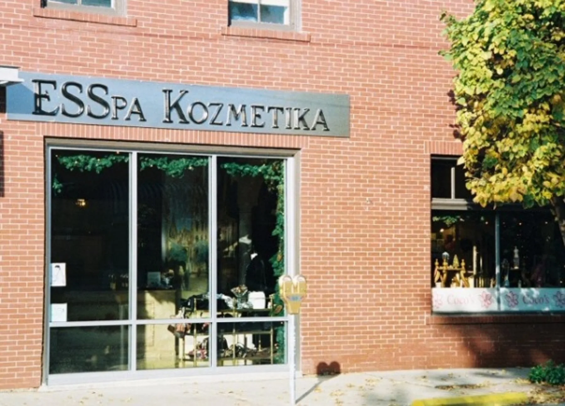 The ESSpa Kozmetika storefront in Aspinwall, its brick facade and tall windows framed by autumn leaves