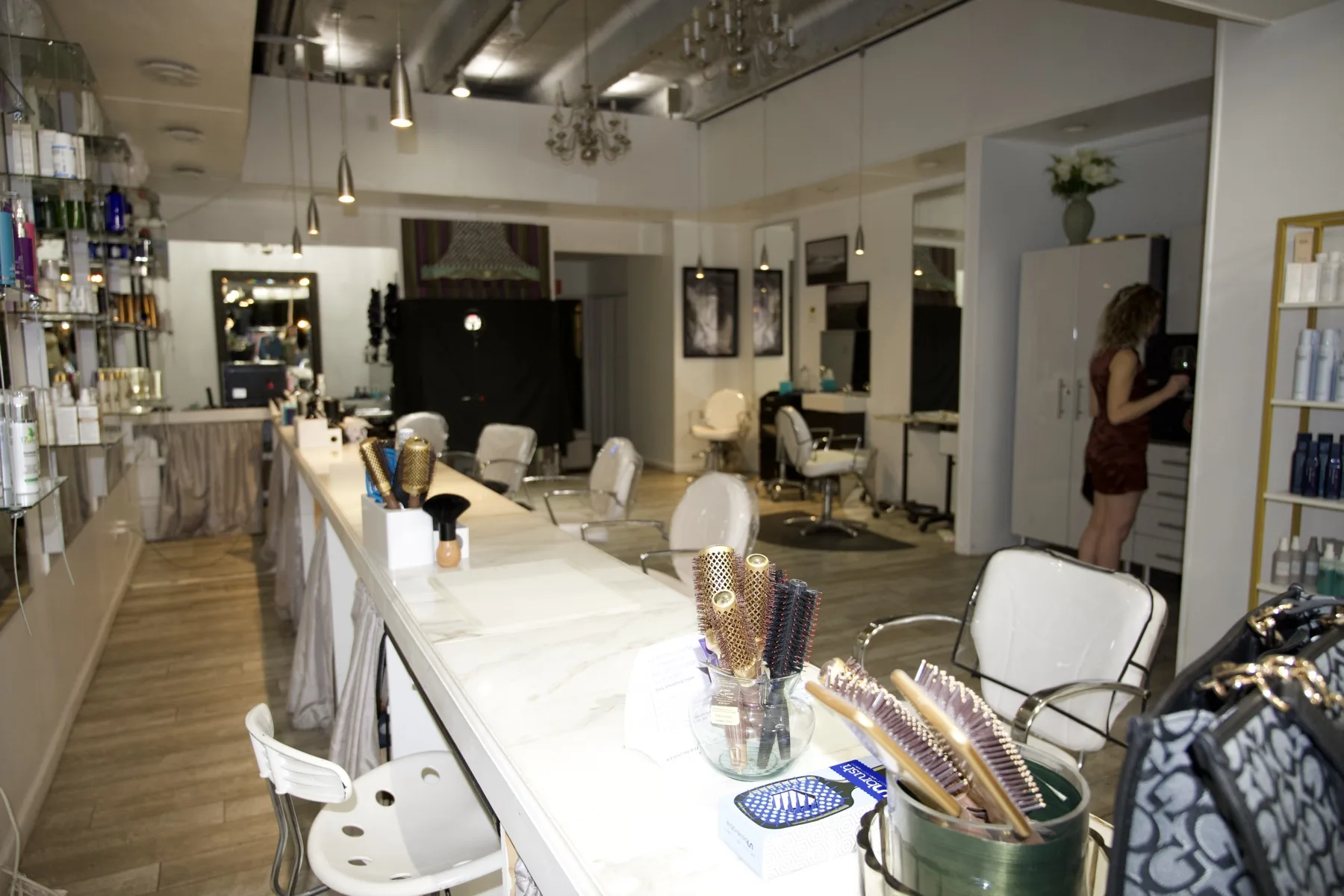 Our blow dry bar at ESSpa Kozmetika, its marble counter lined with round brushes and styling tools beneath a crystal chandelier